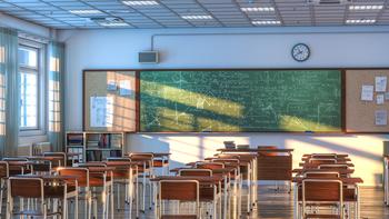 Classroom interior with desks and a chalkboard.