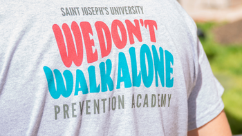 Image of the back of a person wearing a Prevention Academy T-shirt