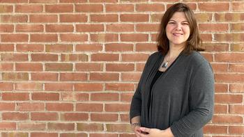Julie Tibbitt, Ph.D., Saint Joseph’s University’s new director of the Deaf and Hard of Hearing program, standing against a brick wall