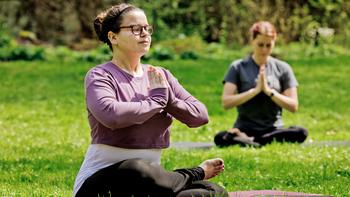 Two women doing yoga outside