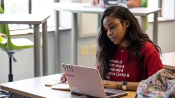 saint joseph's university student on a laptop inside a classroom