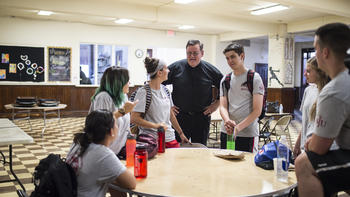 Students a at a table with Fr. Joyce, talking at a retreat
