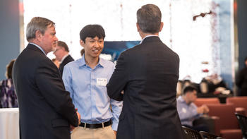 A group of alumni chat in the foley center