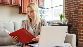 female saint joseph's university online student taking classes from her apartment