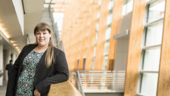 A woman leans on a railing at her co-op