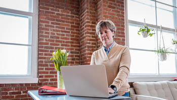 woman doing school work on her laptop at home