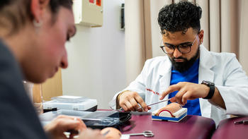 physician assistant student during a suturing lab