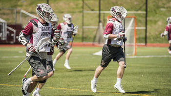 A lacrosse player runs on the field