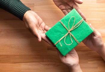 Adult gives a gift present to child.