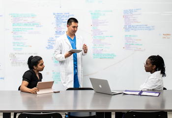 Nursing students at Saint Joseph's University in a classroom with exam material on a whiteboard