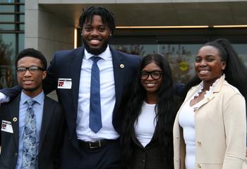 Four Saint Joseph's students standing in front of the Everest Insurance office