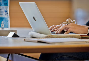 Student typing on laptop