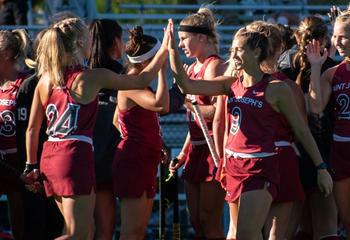 Saint Joseph's field hockey players high-five each other after a game