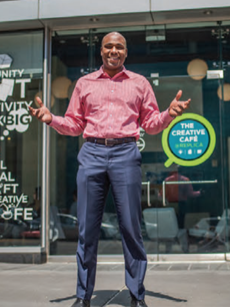 a man wearing a striped dress shirt and dress pants, standing outside