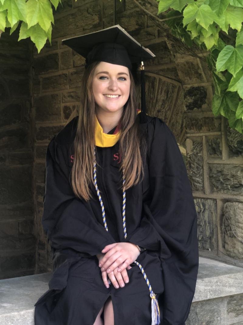 a young woman wearing a graduation robe and cap