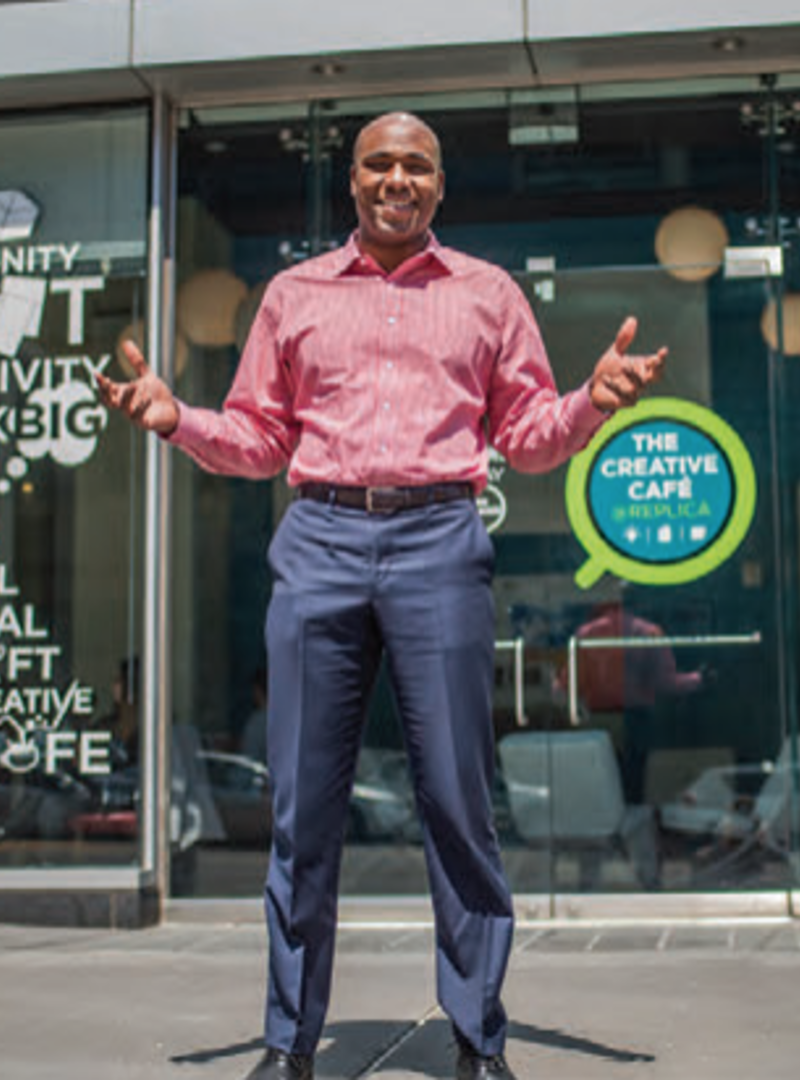 a man wearing a striped dress shirt and dress pants, standing outside