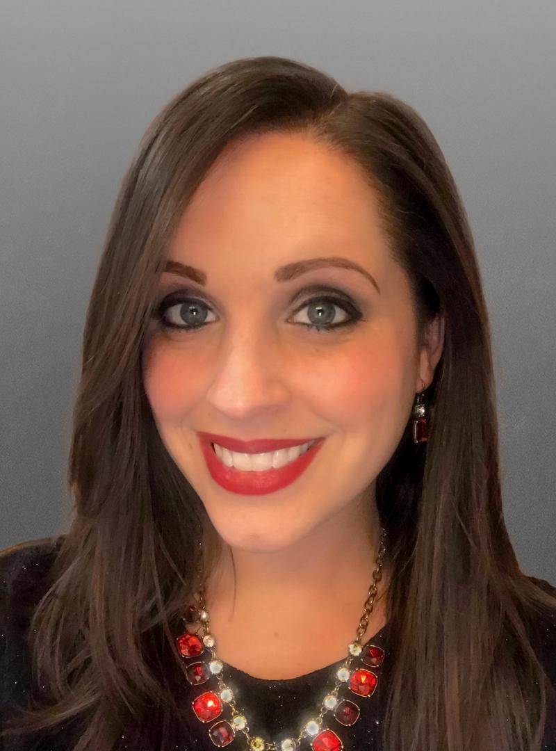 a young woman with dark hair and red lipstick, smiling at the camera