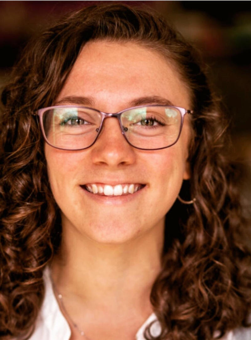 a young woman with glasses and curly hair