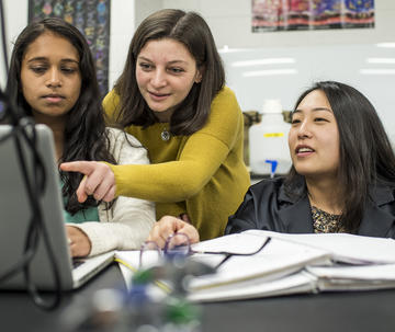 Faculty member at Saint Joseph's University teaching students in a lab in front of a monitor.