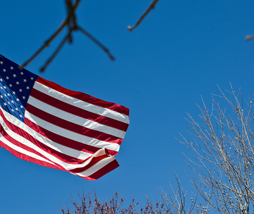 American flag with a blue sky