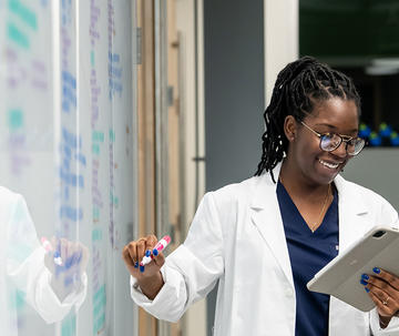 Pharmacy student taking notes on a white board 