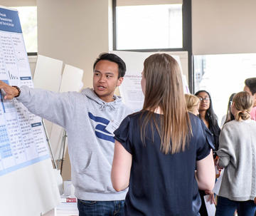 Male Saint Joseph's student presenting his research at symposium