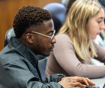 Two Saint Joseph's business students working on laptop in class