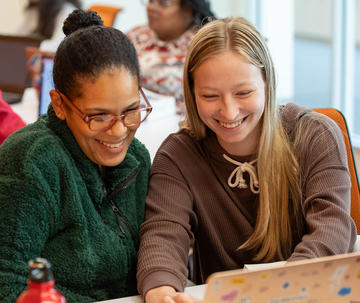 Professor and student working on laptop
