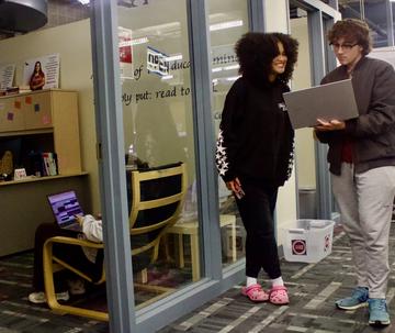 Two students conversing in front of Writing Center PLC location