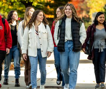Group of male and female Saint Joseph's students walking together outside on campus