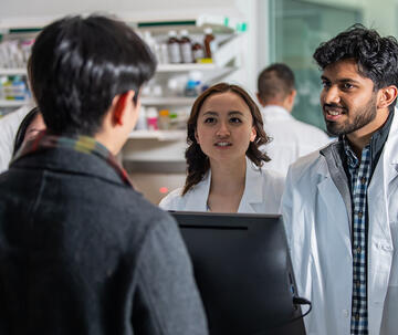 pharmacists at counter helping a customer