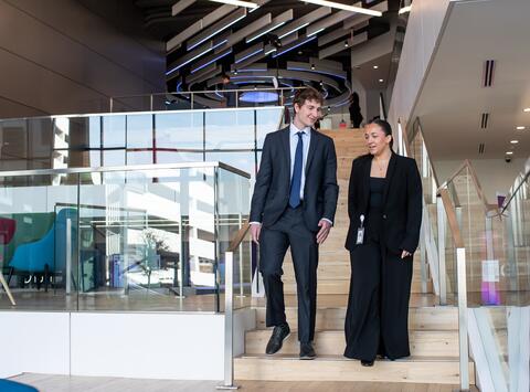 Male and female student walking down steps