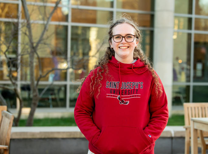 Saint Joseph's University Student standing and smiling on campus.