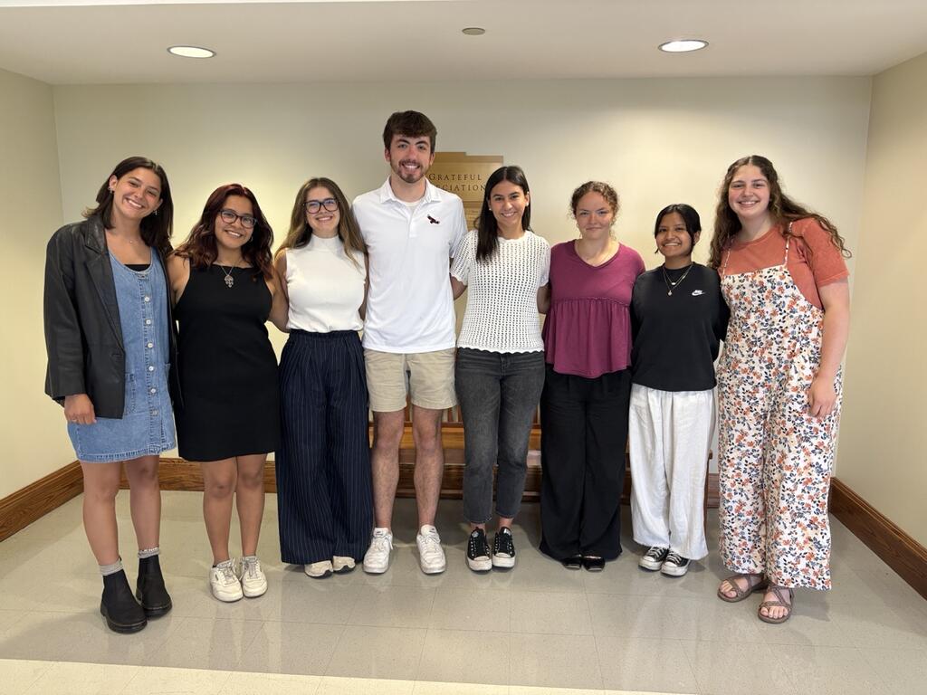 Eight students standing in a line