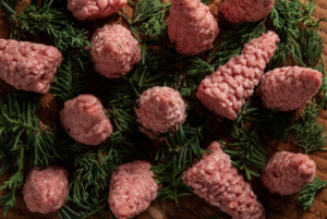 small Christmas trees made of ground beef on Pine needles