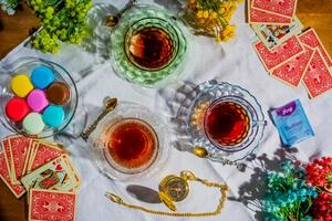 photograph of playing cards, glasses and a watch on table