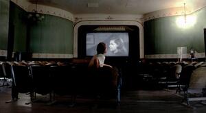 photograph of man in a theatre watching a film