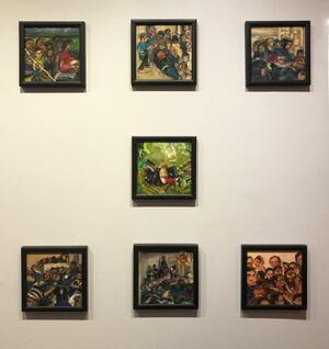 seven paintings on wall in gallery space