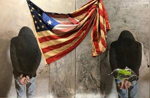 photograph of Puerto Rican flag and two handcuffed persons