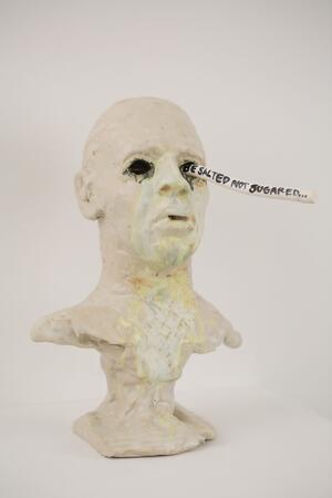 bust of man's head with a paper message coming out of an eye
