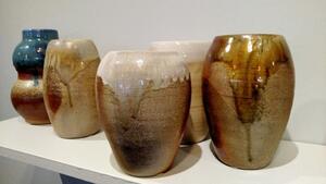 five pottery vases on a stand