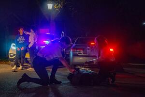 police officers bent over handcuffed man on the ground