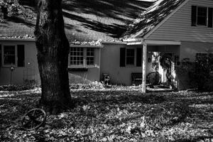 B+W photo of a home with a front yard