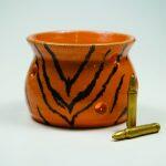 ceramic tiger-striped bowl with 2 bullets next to it