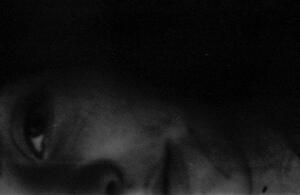 B+W portrait photo of half of a woman's face turned sideways and at the bottom of the frame