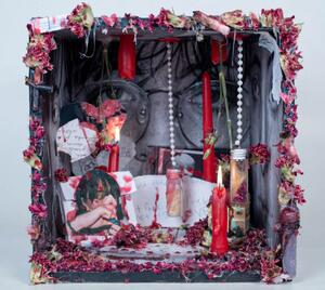 box affixed to wall with candles and beads in it