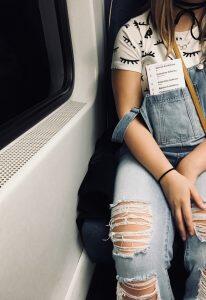 woman with ripped jeans seated on bus